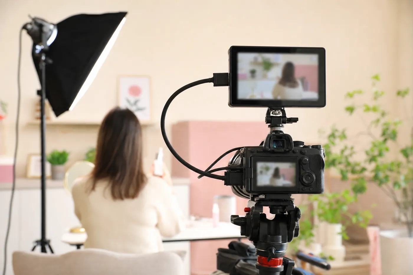 YouTube動画の撮影現場。カメラと外部モニター、デスクに座る出演者の後ろ姿